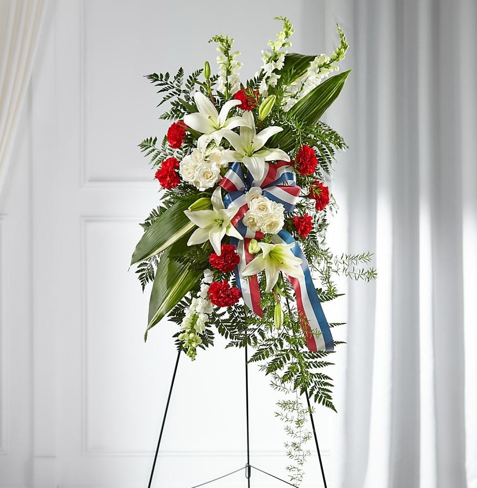 A patriotic spray with red, white, and blue flowers fit for any veteran's funeral
